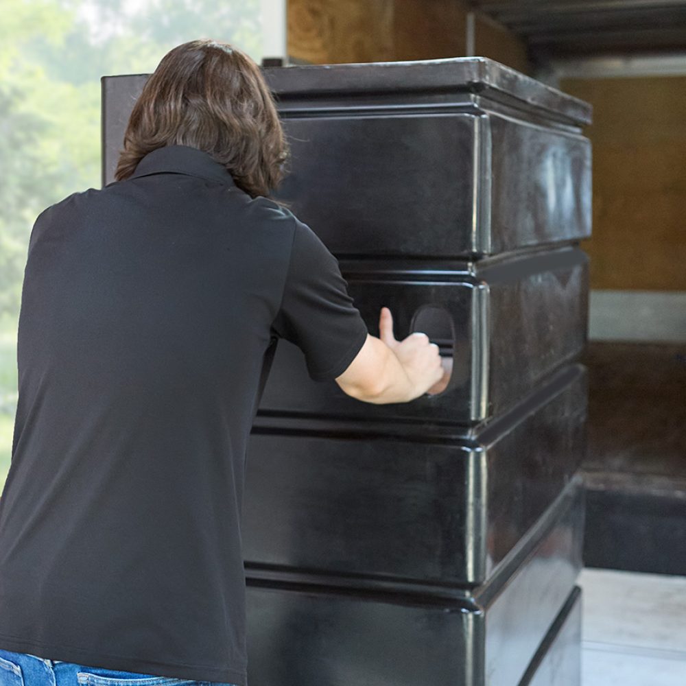 man loading bin of linens onto truck