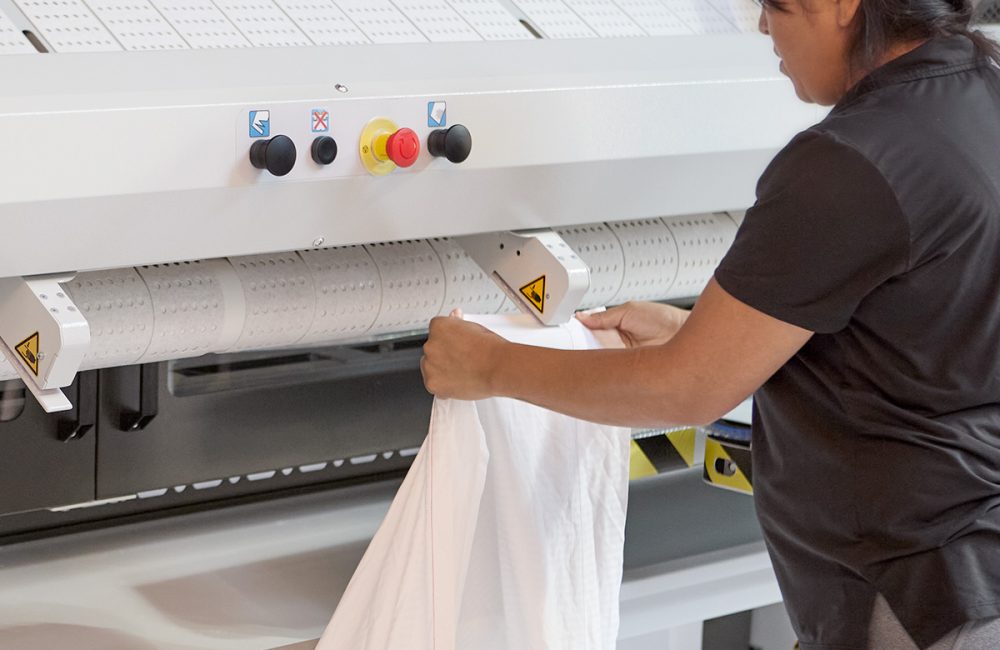 woman putting white linens in machine